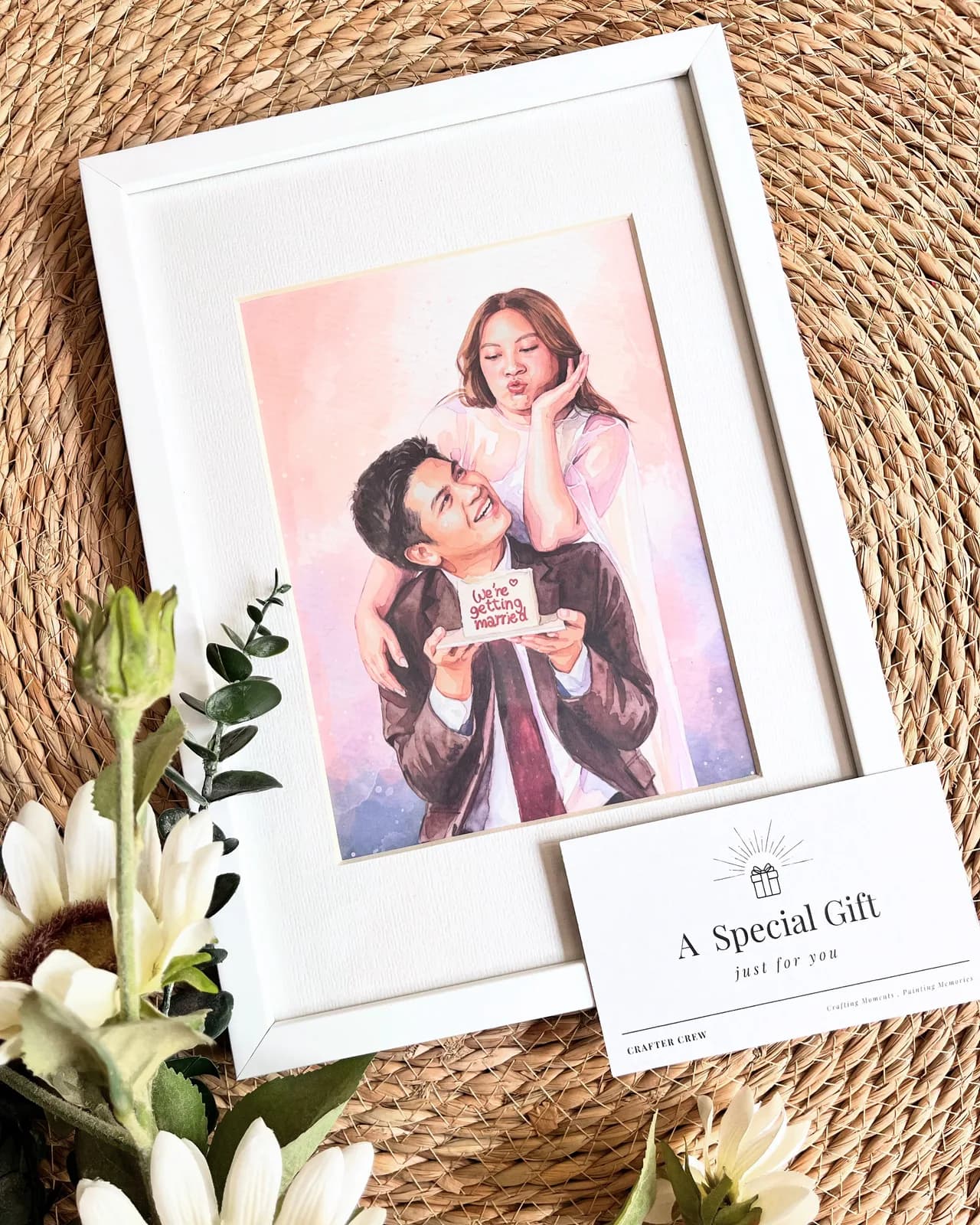 ภาพวาดสีน้ำหนุ่มแบกแฟนสาวขี่หลัง ถือป้าย We're getting married ในกรอบขาว